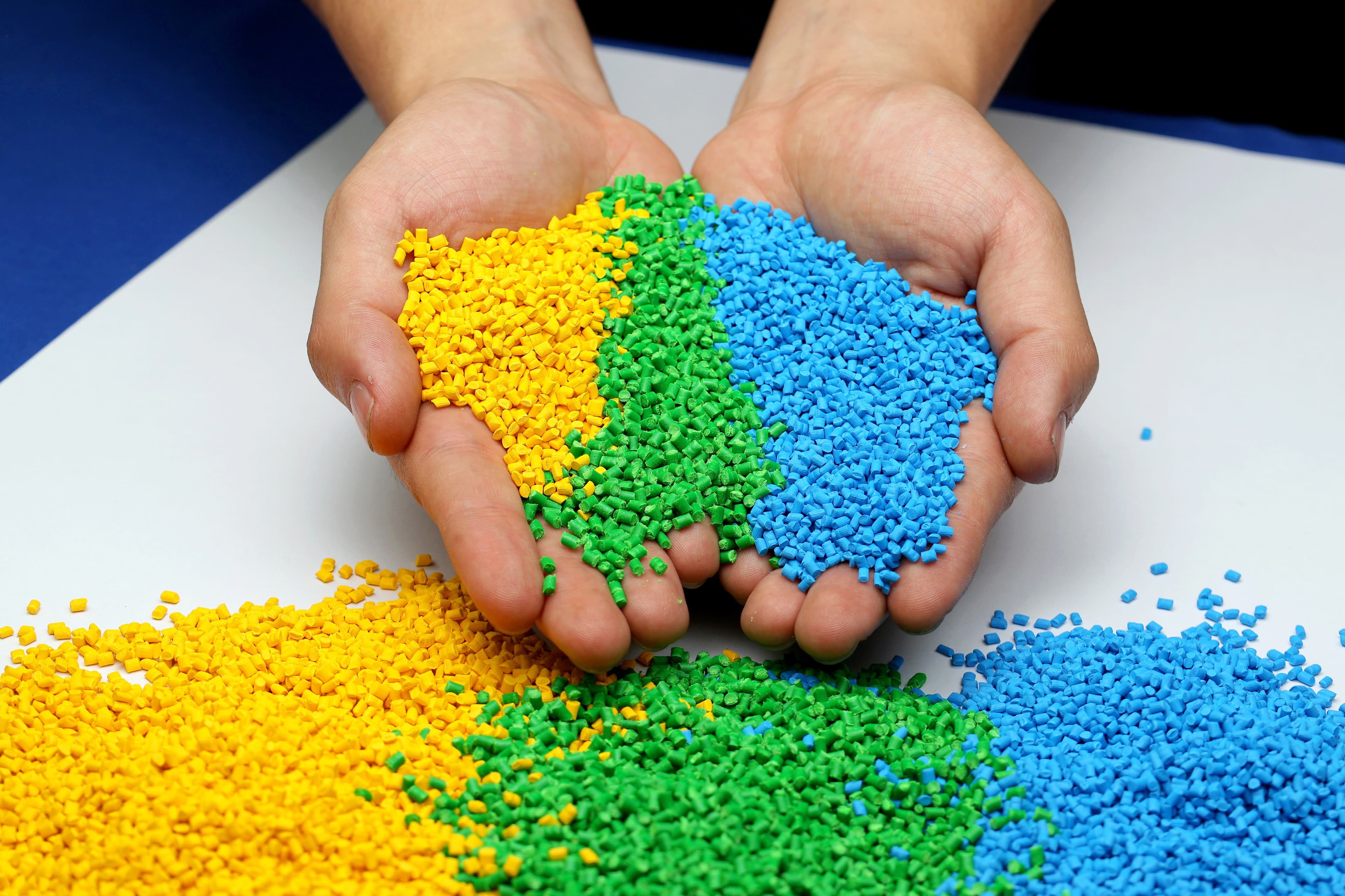 Manos sosteniendo masterbatch de colores